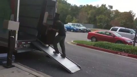 mover walking a cabinet up the moving-truck ramp on a dolly